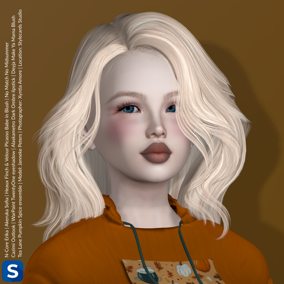 A headshot of Janneke Peters standing in front of a caramel-colored backdrop. She is wearing a festive orange hoodie with some pumpkin decorations on the front. She has long blonde hair, a hint of eyeshadow,some blush on her cheeks, and a brownish lipstick,